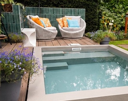 Maatwerk zwembad met houten deck en loungestoelen